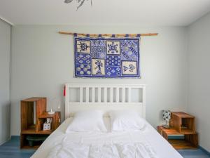 ein Schlafzimmer mit einem weißen Bett und einem blauen und weißen Fenster in der Unterkunft Maison Les Sables-d'Olonne, 4 pièces, 8 personnes - FR-1-197-500 in Les Sables-dʼOlonne