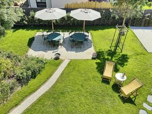 an aerial view of a yard with tables and umbrellas at Maison d'exception à 80m de la plage avec accès direct, proche commerces, terrasse, BBQ, WiFi inclus - FR-1-361-375 in Jullouville-les-Pins