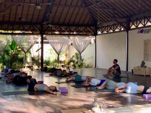 um grupo de pessoas deitadas no chão a fazer yoga em The Yoga Garden em Gili Trawangan