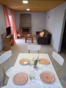 una sala de estar con una mesa con platos. en Cumbreluz, Potrerillos en Potrerillos