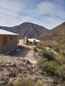 a couple of buildings in the middle of a mountain at Cumbreluz, Potrerillos in Potrerillos