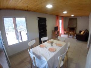 comedor con mesa blanca y sillas en Cumbreluz, Potrerillos en Potrerillos