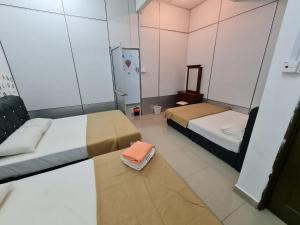 um pequeno quarto com 2 camas e um espelho em Roomstay Gemilang em Kuala Terengganu