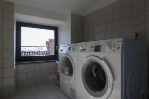 uma máquina de lavar roupa na casa de banho com uma janela em Apartmaji in sobe Marija Jera Štanjel em Stanjel