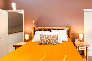 - une chambre avec un grand lit orange et des oreillers dans l'établissement Sunlight Mountain Home with Hot Tub and View!, à Carbondale