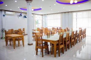 een eetkamer met houten tafels en stoelen bij Saline Hot Spring Resort นำ้พุร้อนเค็ม รีสอร์ท 