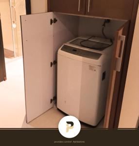 a small washer and dryer in a small kitchen at FULLY FURNISHED STUDIO NEAR MOA in Manila