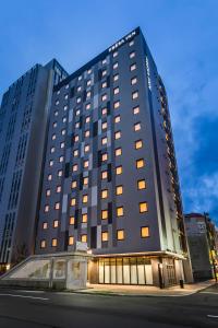a large black building with many windows on a street at Sotetsu Fresa Inn Sapporo-Susukino in Sapporo