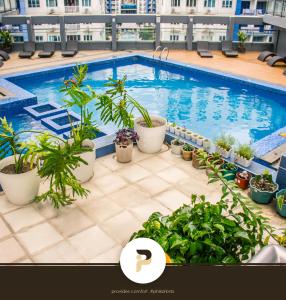 a swimming pool on top of a building with plants at FULLY FURNISHED STUDIO NEAR MOA in Manila