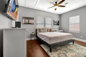a bedroom with a bed and a ceiling fan at Vibrant Vacation Escape with Fast WIFI and KING BED Close to Downtown Houston! in Houston