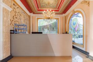 a lobby with a reception desk in a room with a chandelier at Urbanview Palace Syariah Balikpapan by RedDoorz in Balikpapan