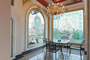 a dining room with a table and chairs and a chandelier at Urbanview Palace Syariah Balikpapan by RedDoorz in Balikpapan