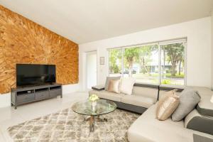 a living room with a couch and a tv at Waterfront 2-Story Villa with Heated Pool in Pembroke Pines