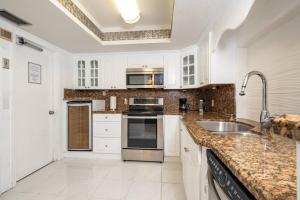 a kitchen with white cabinets and a sink at Waterfront 2-Story Villa with Heated Pool in Pembroke Pines