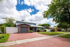a house with a brick driveway in front of it at Waterfront 2-Story Villa with Heated Pool in Pembroke Pines