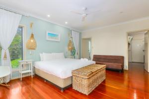a bedroom with a bed and a chair and a couch at Ocean View Apartments by Kingscliff Accommodation in Kingscliff
