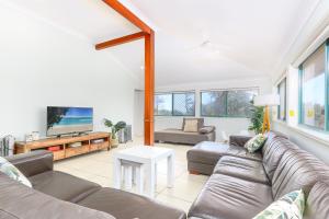 a living room with a couch and a tv at Ocean View Apartments by Kingscliff Accommodation in Kingscliff