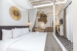 une chambre avec un grand lit blanc et un salon dans l'établissement Casa Andina Premium Cusco, à Cusco