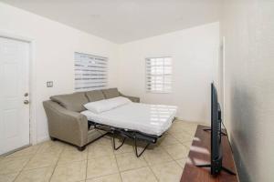 ein Wohnzimmer mit einem Sofa und einem Flachbild-TV in der Unterkunft Beautiful 7-Bedroom Villa with Pool in Hialeah