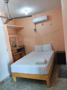 1 dormitorio con 1 cama blanca en una habitación en Casa Bonzay en Bacalar