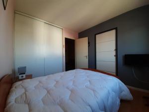 1 dormitorio con 1 cama blanca grande y TV en Appartement Ciboure, 2 pièces, 4 personnes - FR-1-239-623, en Ciboure