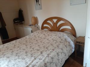a bedroom with a bed with a floral bedspread at Charmant T2 avec jardin privé, proche centre et plages de Capbreton - FR-1-239-632 in Capbreton
