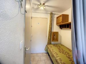 a small bedroom with a bed and a door at Charmant T1 au cœur de Lamalou, à 650m des Thermes, avec Wifi et animaux acceptés - FR-1-451-147 in Lamalou-les-Bains