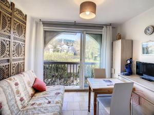 a living room with a couch and a table at Charmant T1 au cœur de Lamalou, à 650m des Thermes, avec Wifi et animaux acceptés - FR-1-451-147 in Lamalou-les-Bains