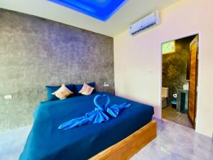 a bedroom with a blue bed with a blue bow on it at Kohyao Non Bay in Ban Nai Wat