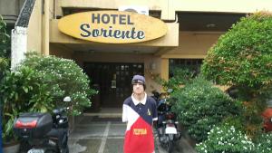 um homem parado em frente à entrada de um hotel em Hotel Soriente em Manilla