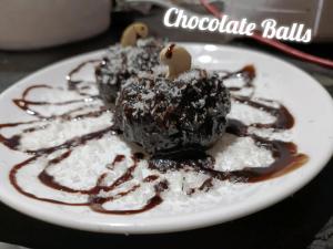 un piatto bianco con palle di cioccolato sopra al riso di Greenstone Resort Hampi a Hampi