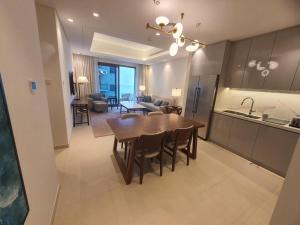 a kitchen and living room with a wooden table and a dining room at Address Beach Resort Residence Fujairah in Fujairah