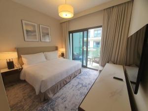 a hotel room with a bed and a large window at Address Beach Resort Residence Fujairah in Fujairah