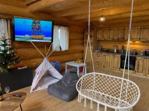 a living room with swing chairs and a television at Medveď, Vlk, Líška Zrubová rozprávka nad rybníkom in Kostolná Ves