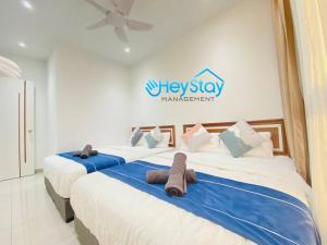 a group of three beds in a room at Bali Residence Melaka By Heystay Management in Melaka