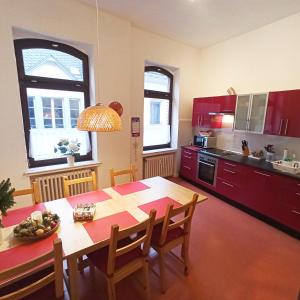 a kitchen with a wooden table and a kitchen with red cabinets at Living in the historic Cochem Old Town in Cochem