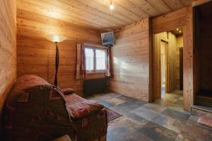 a room in a log cabin with a bed and a lamp at Chalet de l'Alpage - Happy Rentals in Les Houches