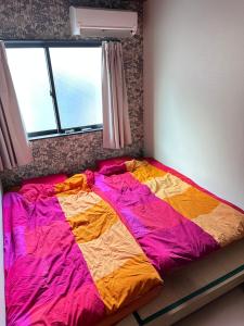 大阪市にある智TOMOのベッドルーム1室(大型ベッド1台、カラフルな掛け布団付)