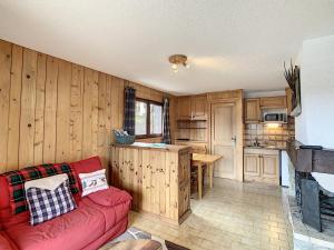un soggiorno con divano rosso e una cucina di Studio Combloux, 1 pièce, 4 personnes - FR-1-560-70 a Combloux