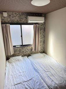 大阪市にある智TOMOの窓付きの部屋のベッド1台