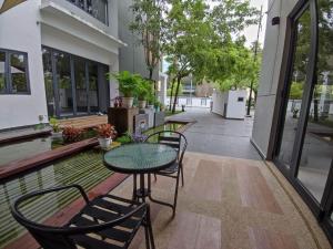 a patio with a table and chairs and a building at Bunga Raya Villa By Malvacae Homestays Shah Alam in Shah Alam
