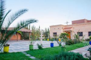 a courtyard with palm trees and a building at Villa world Marrakech in Marrakesh