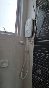 a shower in a bathroom with a window and a hose at HOMESTAY @ BANDAR SERI PUTRA KAJANG in Kajang