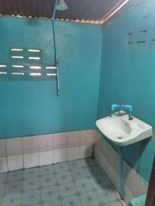 baño con lavabo y pared azul en Kulap Kao Bungalow, en Ban Donsôm Tai