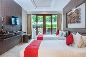 a hotel room with two beds and a television at Khayangan Kemenuh Villas by Premier Hospitality Asia in Sukawati