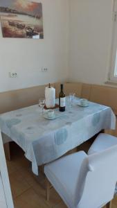 - une table blanche avec une bouteille de vin dans l'établissement Apartment Goran - sea view, à Okrug Donji
