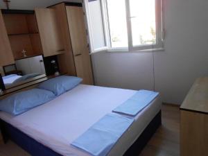 Cette chambre comprend un grand lit et une fenêtre. dans l'établissement Apartment Goran - sea view, à Okrug Donji