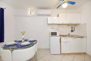 cocina con mesa y nevera blanca en Apartments Ines - central with free parking, en Betina
