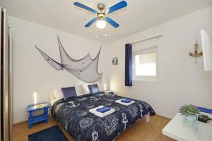 1 dormitorio con 1 cama y ventilador de techo en Apartments Ines - central with free parking, en Betina