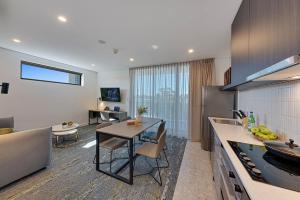 a kitchen and living room with a table and a counter at Littomore Suites Kingswood in Penrith